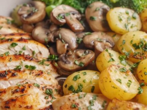 A cozy dinner bowl filled with sliced grilled chicken, herb-roasted baby potatoes, and vibrant broccoli