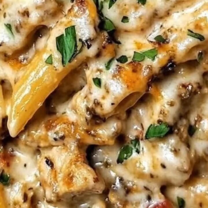 A close-up of baked garlic butter chicken penne in a skillet, topped with golden