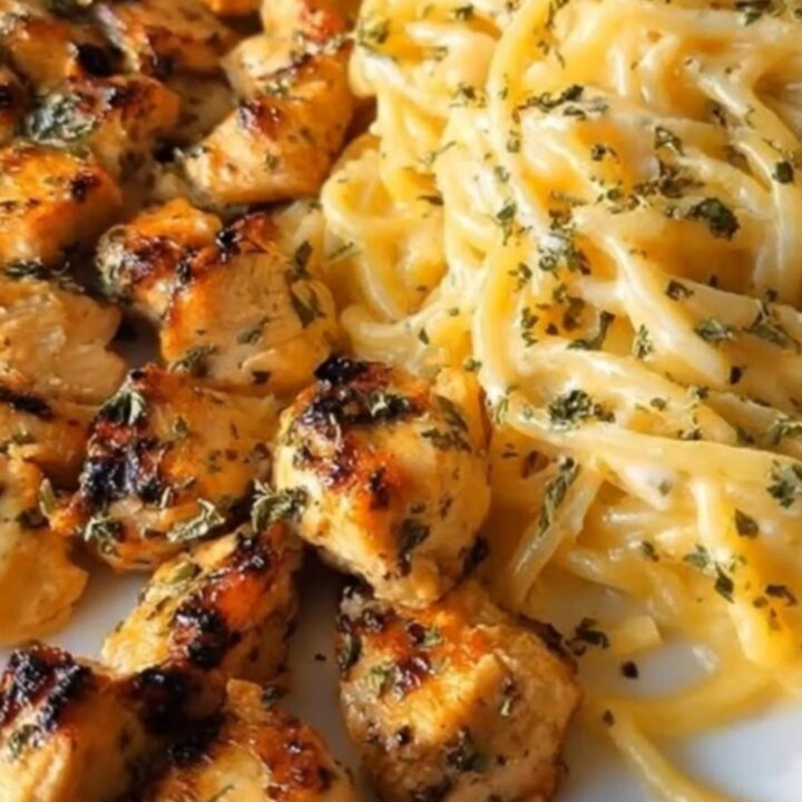 A plate of garlic butter chicken spaghetti coated in a rich, creamy cheddar parmesan sauce.
