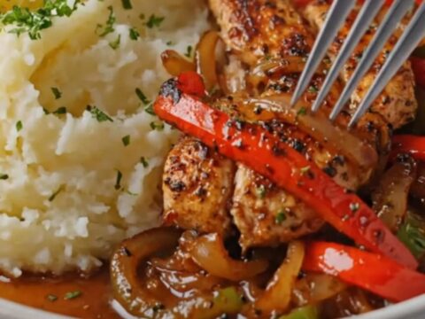 A warm plate featuring golden seared chicken strips, vibrant sautéed bell peppers