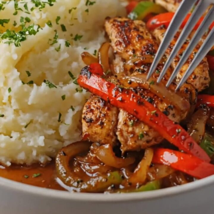 A warm plate featuring golden seared chicken strips, vibrant sautéed bell peppers