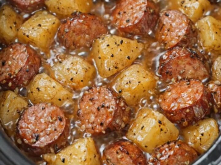 A warm bowl of tender slow-cooked Yukon Gold potatoes and savory smoked sausage slices in a glossy butter sauce.