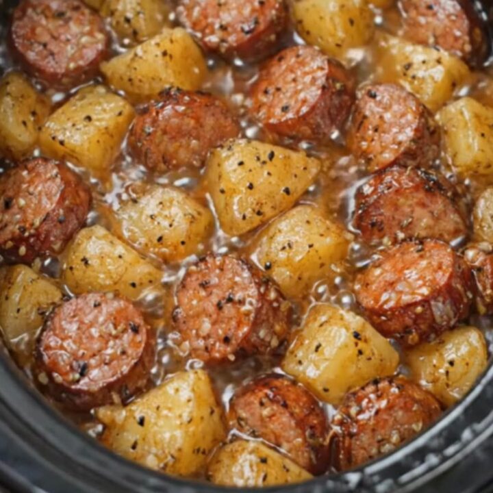 A warm bowl of tender slow-cooked Yukon Gold potatoes and savory smoked sausage slices in a glossy butter sauce.