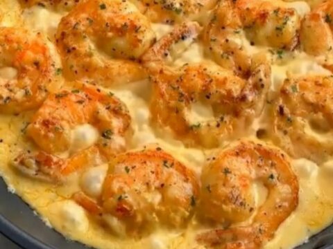 Plump golden-seared shrimp dripping with rich, velvety garlic cream sauce lifted on a fork
