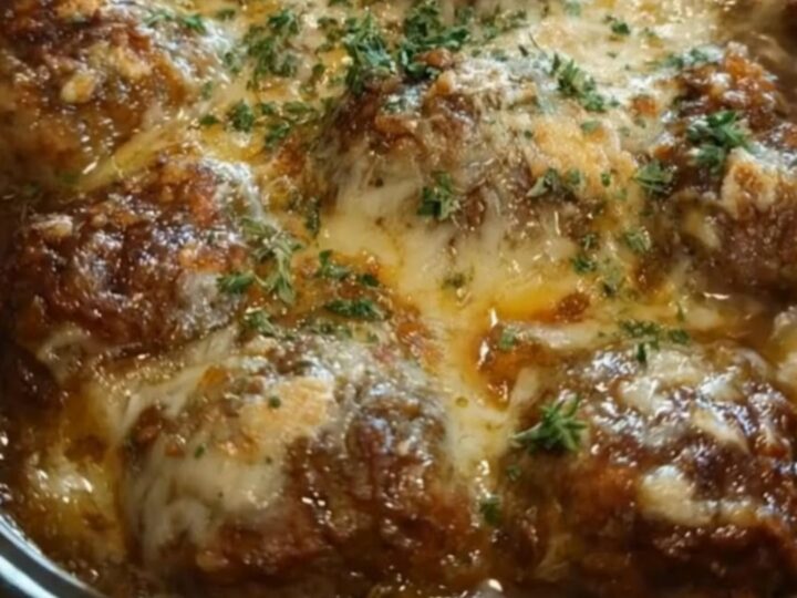 Slow cooker filled with savory French onion beef meatballs topped with a blanket of melted