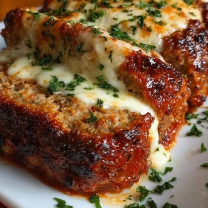 A warm slice of Italian meatloaf being pulled away, revealing a thick, stretchy mozzarella cheese pull.