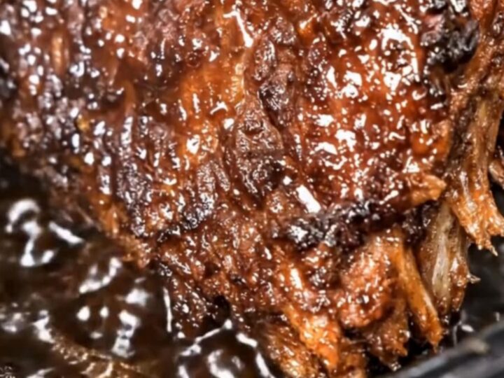 Tender slow cooker cola ribs with a rich, sticky, caramelized barbecue glaze pulling apart as rising steam escapes.