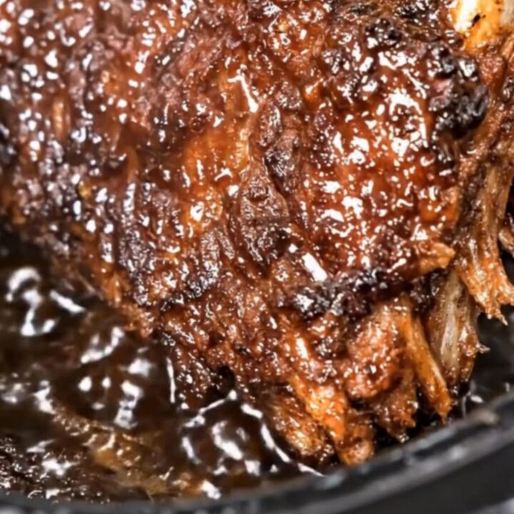 Tender slow cooker cola ribs with a rich, sticky, caramelized barbecue glaze pulling apart as rising steam escapes.