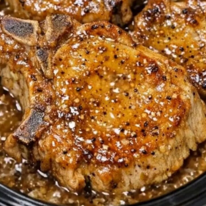 A succulent bone-in pork chop glazed with sticky honey garlic sauce, sliced open to reveal juicy meat inside.