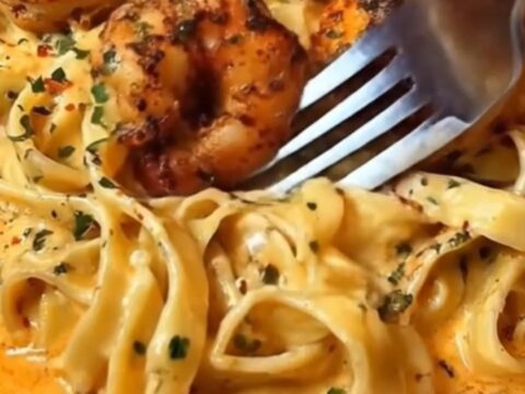 A white bowl filled with creamy Cajun garlic shrimp fettuccine alfredo, garnished with fresh parsley.