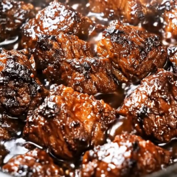 A close-up shot of caramelized, tender country-style boneless pork ribs simmering in a slow cooker.