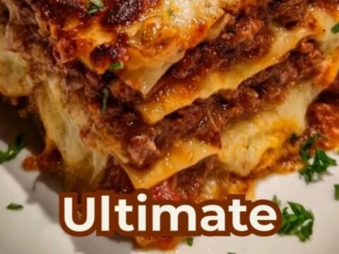 A thick-layered slice of classic cheesy beef lasagna on a white plate