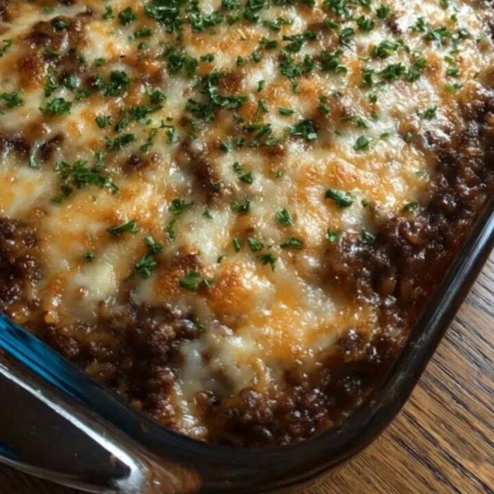 A portion of French Onion Ground Beef and Rice Casserole being lifted with a spatula, showing an epic stretchy cheese pull.
