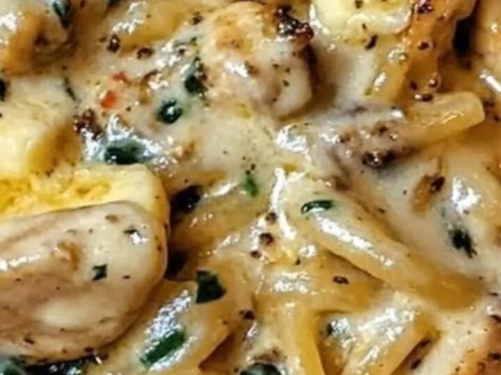 A warm bowl of creamy chicken spinach alfredo spaghetti with steam rising from the glossy sauce.