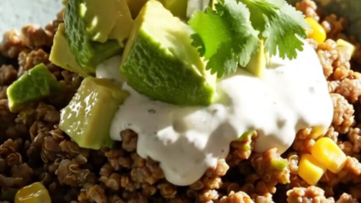 A warm, bubbling slow cooker filled with green chile beef and quinoa bake topped with melted cheese.