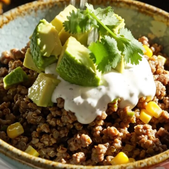 A warm, bubbling slow cooker filled with green chile beef and quinoa bake topped with melted cheese.