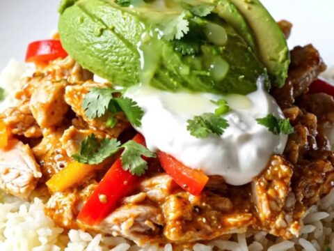 A close-up view of the slow-cooker Buffalo-Tex-Mex chicken casserole with bubbling cheese and peppers.