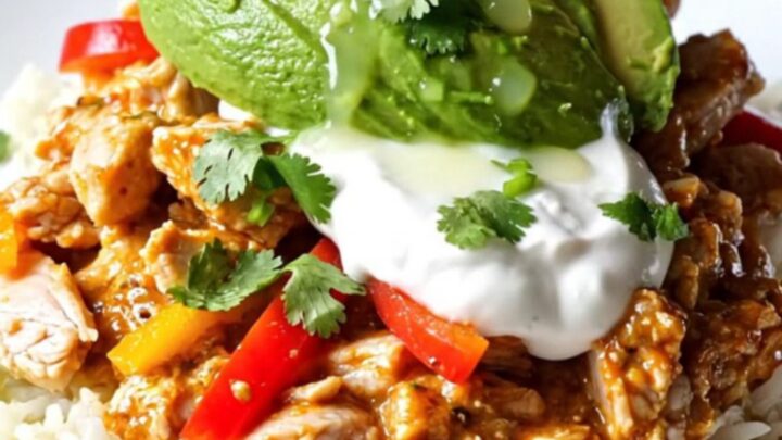 A close-up view of the slow-cooker Buffalo-Tex-Mex chicken casserole with bubbling cheese and peppers.