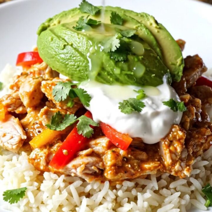 A close-up view of the slow-cooker Buffalo-Tex-Mex chicken casserole with bubbling cheese and peppers.