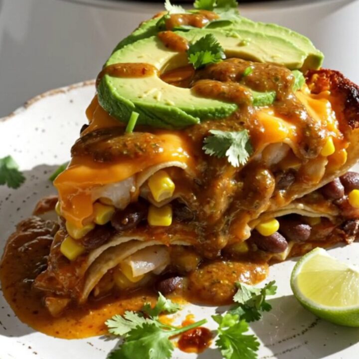 A warm, cheesy slow-cooker shrimp enchilada bake with visible layers of tortillas, shrimp, and black beans.