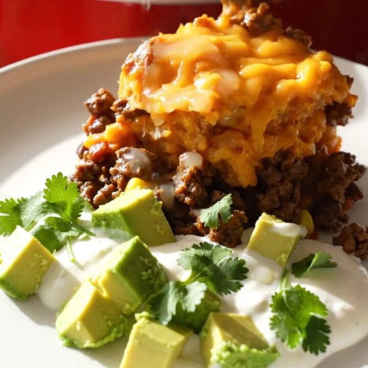 A close-up view of the slow-cooker shepherd's pie with a golden cheese crust and mashed sweet potatoes.