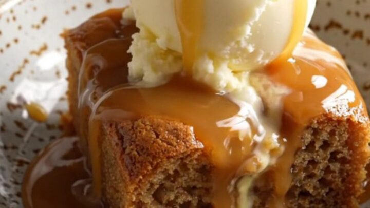 A warm bowl of banana caramel walnut dump cake topped with a melting scoop of vanilla ice cream.