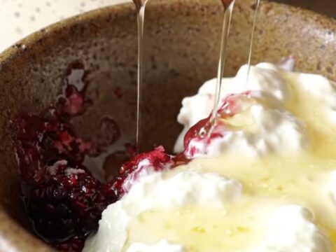 A rustic Crockpot filled with bubbling mixed berry oatmeal dump cake topped with a crispy, golden crust.