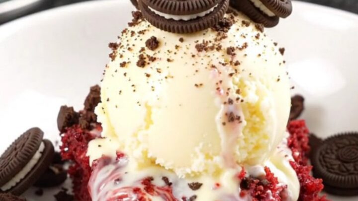 A crimson red velvet Oreo dump cake in a red Crockpot, with cream cheese and chocolate ribbons visible.