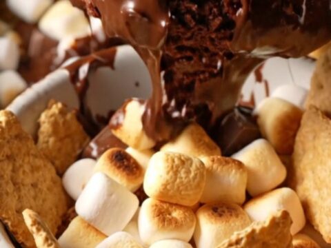 Extreme close-up of a charcoal stoneware slow cooker filled with a bubbling s'mores hot fudge cake topped with toasted