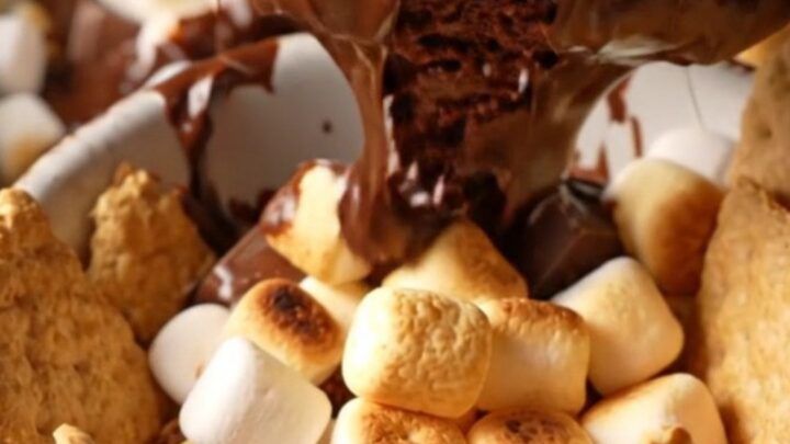 Extreme close-up of a charcoal stoneware slow cooker filled with a bubbling s'mores hot fudge cake topped with toasted