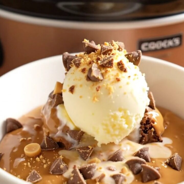 Close-up of a molten Reese's brownie pudding in a slow cooker with chocolate sauce.