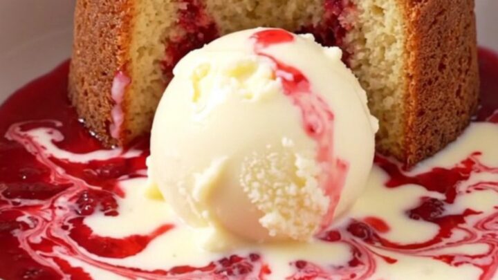 A close-up of a white chocolate raspberry lava cake being scooped from a ceramic slow cooker.