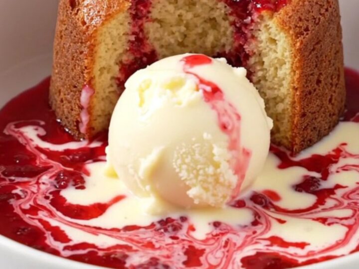A close-up of a white chocolate raspberry lava cake being scooped from a ceramic slow cooker.