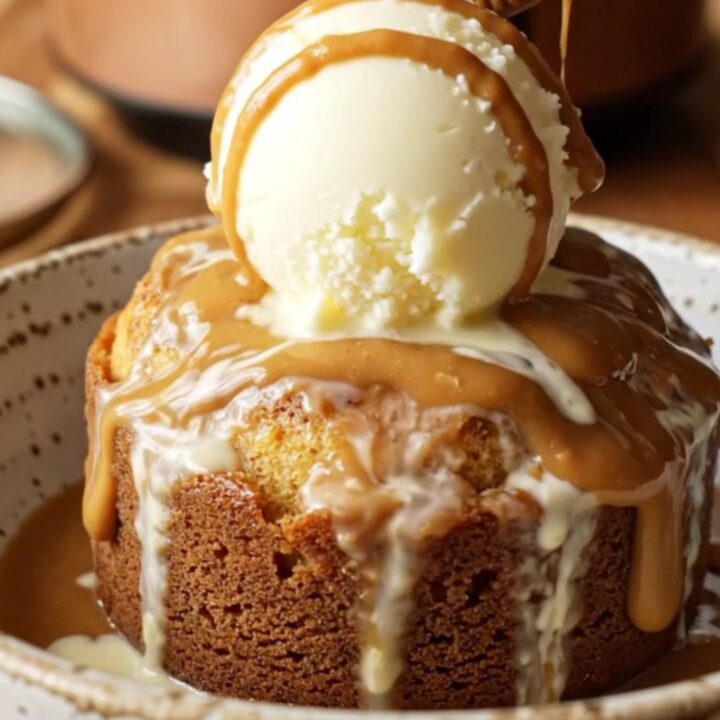 A steaming, golden Biscoff lava cake in a slow cooker, topped with ice cream and a whole cookie.