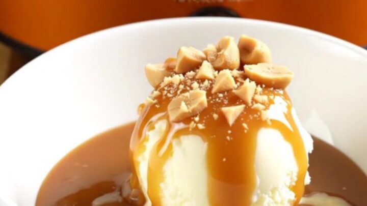 A warm Snickers lava cake in a slow cooker with a spoon scooping out a gooey, caramel-filled portion.