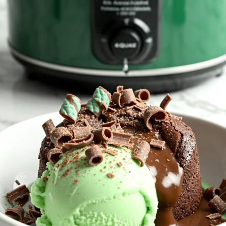 A close-up of a dark chocolate Crockpot lava cake being scooped to reveal a molten mint fudge center.