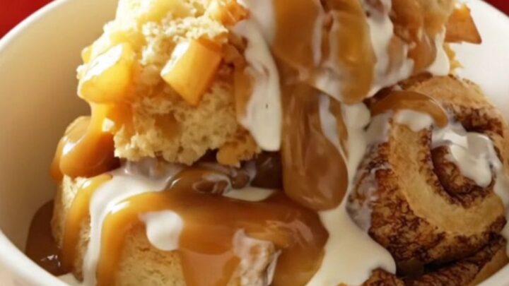 A steaming Crockpot filled with golden, fluffy cinnamon rolls topped with spiced apples and caramel.
