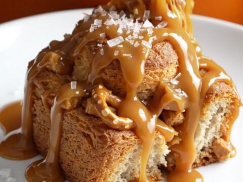 A close-up shot of slow cooker caramel pretzel monkey bread with bubbling caramel and golden biscuit dough.