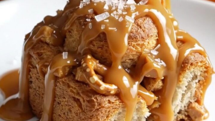 A close-up shot of slow cooker caramel pretzel monkey bread with bubbling caramel and golden biscuit dough.