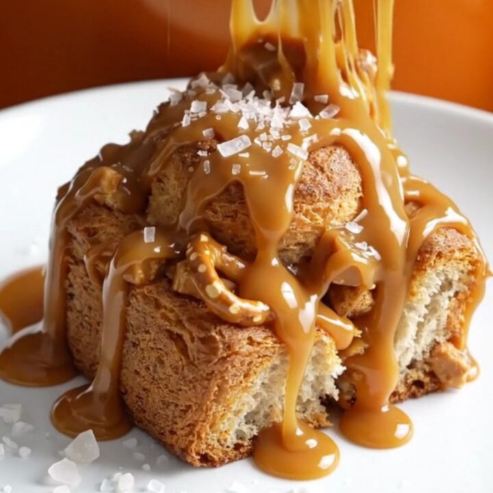 A close-up shot of slow cooker caramel pretzel monkey bread with bubbling caramel and golden biscuit dough.