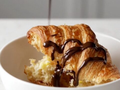 A warm churro croissant casserole in a square baking dish with golden-brown, crispy tops.