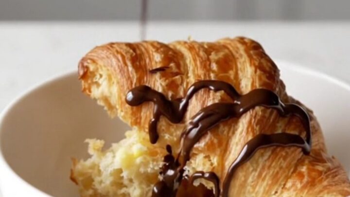 A warm churro croissant casserole in a square baking dish with golden-brown, crispy tops.