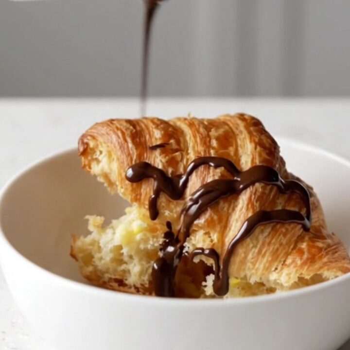A warm churro croissant casserole in a square baking dish with golden-brown, crispy tops.