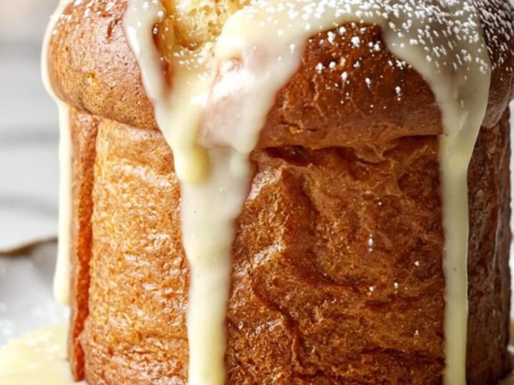 A close-up of a golden, creamy white chocolate and cranberry bread pudding served in a festive holiday setting.