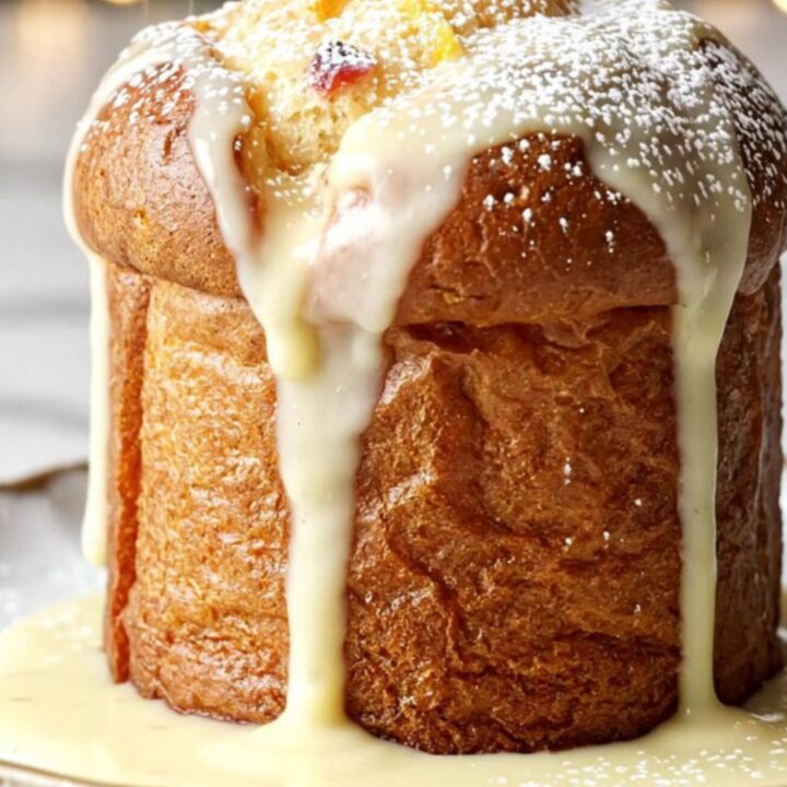 A close-up of a golden, creamy white chocolate and cranberry bread pudding served in a festive holiday setting.