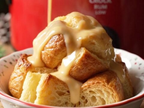 A festive bowl of golden eggnog rum bread pudding drizzled with creamy glaze and dusted with fresh nutmeg.