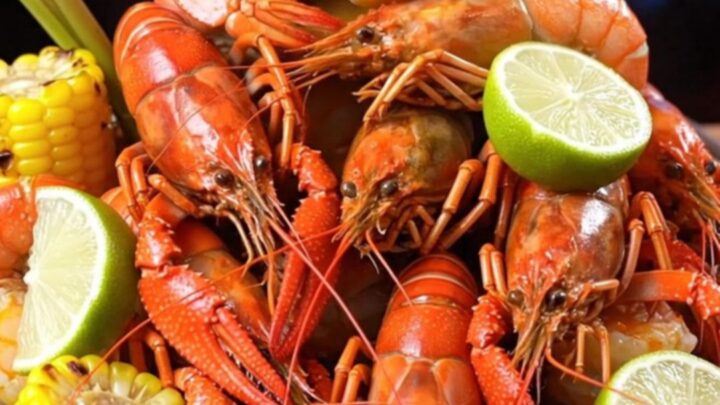 A vibrant Houston-style Viet-Cajun crawfish and shrimp boil served on a galvanized tray with lime.