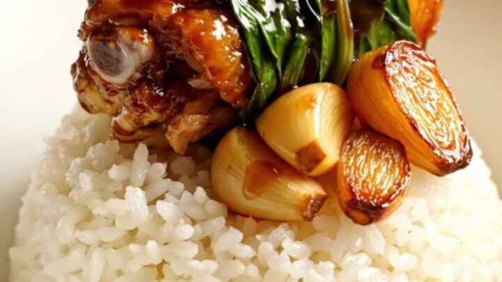 Taiwanese Three-Cup Chicken served in a ceramic bowl with steamed rice and fresh Thai basil.