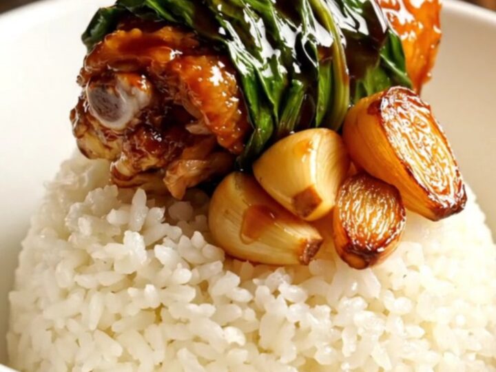 Taiwanese Three-Cup Chicken served in a ceramic bowl with steamed rice and fresh Thai basil.