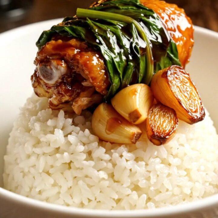 Taiwanese Three-Cup Chicken served in a ceramic bowl with steamed rice and fresh Thai basil.